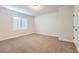 A neutral bedroom with carpet flooring, a window, and a white door at 15102 Prairie Pl, Broomfield, CO 80023