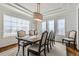 Formal dining room boasts natural light, elegant chandelier, and a large table with seating for six at 15102 Prairie Pl, Broomfield, CO 80023