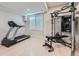 A spacious home gym featuring a treadmill, weight machine, light wood flooring, and a window at 15102 Prairie Pl, Broomfield, CO 80023