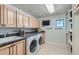 Well-appointed laundry room with shaker cabinets, granite countertops, and built-in shelving at 15102 Prairie Pl, Broomfield, CO 80023