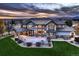 Expansive backyard featuring a covered patio, stone fireplace, and well-manicured lawn at 15102 Prairie Pl, Broomfield, CO 80023