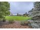 Expansive backyard showcasing plush grass, mature trees, and professional landscaping at 15102 Prairie Pl, Broomfield, CO 80023