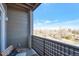 Balcony view with bench and a railing overlooking a tree lined street with homes and a blue sky at 400 E Fremont Pl # 207, Centennial, CO 80122