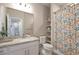 Neutral bathroom with modern finishes, granite countertop vanity, walk-in shower with floral curtain, and decorative shelves at 400 E Fremont Pl # 207, Centennial, CO 80122