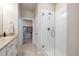 Bright bathroom featuring a glass walk-in shower, beige tile floors, and an open closet with hanging clothes at 400 E Fremont Pl # 207, Centennial, CO 80122