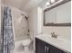 Clean bathroom with a marble-tiled tub/shower and dark vanity at 750 S Clinton St # 2C, Denver, CO 80247