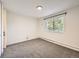 Sunlit bedroom features neutral carpet, white walls, and a sunny window at 750 S Clinton St # 2C, Denver, CO 80247