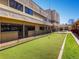 Outdoor bocce ball court with artificial turf and black fence at 750 S Clinton St # 2C, Denver, CO 80247