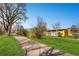 Building exterior surrounded by grassy lawn and mature shade trees at 750 S Clinton St # 2C, Denver, CO 80247