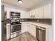 Modern kitchen featuring stainless steel appliances and dark gray tile backsplash at 750 S Clinton St # 2C, Denver, CO 80247