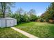 Expansive backyard featuring a lush lawn, mature trees, storage shed, and a well-maintained perimeter fence at 8020 W 46Th Cir, Wheat Ridge, CO 80033