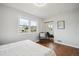 Inviting bedroom with hardwood floors, a cozy chair, and lots of natural light from two windows at 8020 W 46Th Cir, Wheat Ridge, CO 80033