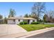 Inviting single-story home featuring a well-manicured lawn, mature trees, and an extended driveway leading to a one car garage at 8020 W 46Th Cir, Wheat Ridge, CO 80033