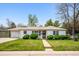 Charming single-story home with lush green lawn and manicured landscaping, with an attached one car garage at 8020 W 46Th Cir, Wheat Ridge, CO 80033