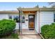 Close-up of a front porch with metal security door, framed window and manicured bushes at 8020 W 46Th Cir, Wheat Ridge, CO 80033