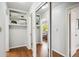 Hallway featuring hardwood floors, mirrored closet, and built-in shelving, providing ample storage at 8020 W 46Th Cir, Wheat Ridge, CO 80033