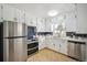An open kitchen showcasing white cabinets, stainless steel appliances, a garden window and decorative tile backsplash at 8020 W 46Th Cir, Wheat Ridge, CO 80033