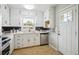 Well-lit kitchen with white cabinets, stainless steel appliances, and a view to the back entryway at 8020 W 46Th Cir, Wheat Ridge, CO 80033