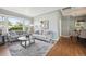 Inviting living area with hardwood floors, neutral tones, comfortable seating, and ample natural light from a large window at 8020 W 46Th Cir, Wheat Ridge, CO 80033