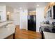 Open-concept kitchen with modern black appliances, wood cabinets, and convenient pantry access at 23625 E Kettle Pl, Aurora, CO 80016