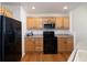 Efficient kitchen design with wooden cabinets, sleek black appliances, and functional layout at 23625 E Kettle Pl, Aurora, CO 80016