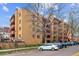 Apartment building with brick facade, red balconies and mature landscaping, with street parking at 625 N Pennsylvania St # 208, Denver, CO 80203