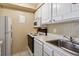 Galley style kitchen with white cabinets, range, microwave and tile flooring at 625 N Pennsylvania St # 208, Denver, CO 80203
