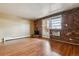 Apartment living room with brick accent wall, fireplace, and hardwood floors at 625 N Pennsylvania St # 208, Denver, CO 80203