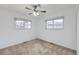 Bright bedroom features neutral walls, plush carpet, two windows and a ceiling fan at 427 Hickory St, Broomfield, CO 80020