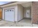 Attached garage with glass panel door, front door with decorative glass, and brick accents at 427 Hickory St, Broomfield, CO 80020