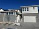 Two-story home with gray siding, stone accents, and a three-car garage at 610 Coal Bank Trl, Castle Rock, CO 80104