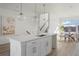 Open-concept kitchen with island seating, modern finishes, and adjacent dining area at 6959 E Lowry Blvd, Denver, CO 80230
