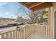 A cozy balcony with wood floors overlooks a parking area and mature trees at 7395 E Quincy Ave # 207, Denver, CO 80237