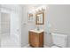 Well-lit bathroom includes a wood vanity, decorative mirrors, white tile and shower with tub at 7395 E Quincy Ave # 207, Denver, CO 80237