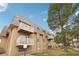 Tan condo building with balconies and well-maintained landscaping at 7395 E Quincy Ave # 207, Denver, CO 80237