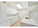 Updated kitchen with stainless steel sink, white cabinets, and backsplash at 7395 E Quincy Ave # 207, Denver, CO 80237