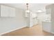 Open kitchen and dining area with tile flooring and white cabinets at 7395 E Quincy Ave # 207, Denver, CO 80237