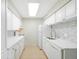 Bright kitchen featuring all white cabinetry, appliances, countertops, and a mosaic tile backsplash at 7395 E Quincy Ave # 207, Denver, CO 80237