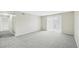 Open living room area with plush gray carpeting and a sliding glass door at 7395 E Quincy Ave # 207, Denver, CO 80237