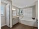Bright bathroom features a soaking tub, granite counters and shuttered windows at 3929 Spanish Oaks Trl, Castle Rock, CO 80108