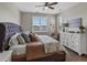 Relaxing main bedroom offers natural light from shuttered windows, a ceiling fan and a sitting area at 3929 Spanish Oaks Trl, Castle Rock, CO 80108