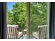 Relax on this outdoor balcony with two chairs, table, and peaceful nature views from the sliding glass door at 505 Orchard Dr, Louisville, CO 80027