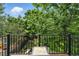 Cozy outdoor deck featuring wrought iron railing and lush greenery for a private and serene setting at 505 Orchard Dr, Louisville, CO 80027