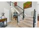 Grand foyer featuring a staircase with iron railings, tiled floors, and artwork for a welcoming entrance at 505 Orchard Dr, Louisville, CO 80027