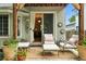 Charming covered patio with outdoor seating, decorative plants, and a view into the living space at 505 Orchard Dr, Louisville, CO 80027