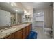 Well-lit bathroom featuring a double vanity, granite countertops, and a walk-in closet at 7679 S Biloxi Way, Aurora, CO 80016