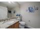 Elegant bathroom with a granite countertop, floral accents, and a large mirror at 7679 S Biloxi Way, Aurora, CO 80016