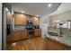 Open kitchen featuring wood floors, granite countertops, stainless steel appliances, and ample lighting at 7679 S Biloxi Way, Aurora, CO 80016