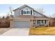 Charming two-story home with a gray exterior, brick accents, a two-car garage, and a well-maintained front yard at 9271 Wheeler Ct, Highlands Ranch, CO 80126