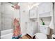 Cozy bathroom featuring a shower-tub combo, white vanity, and decorative colorful shower curtain at 3106 N Franklin St, Denver, CO 80205